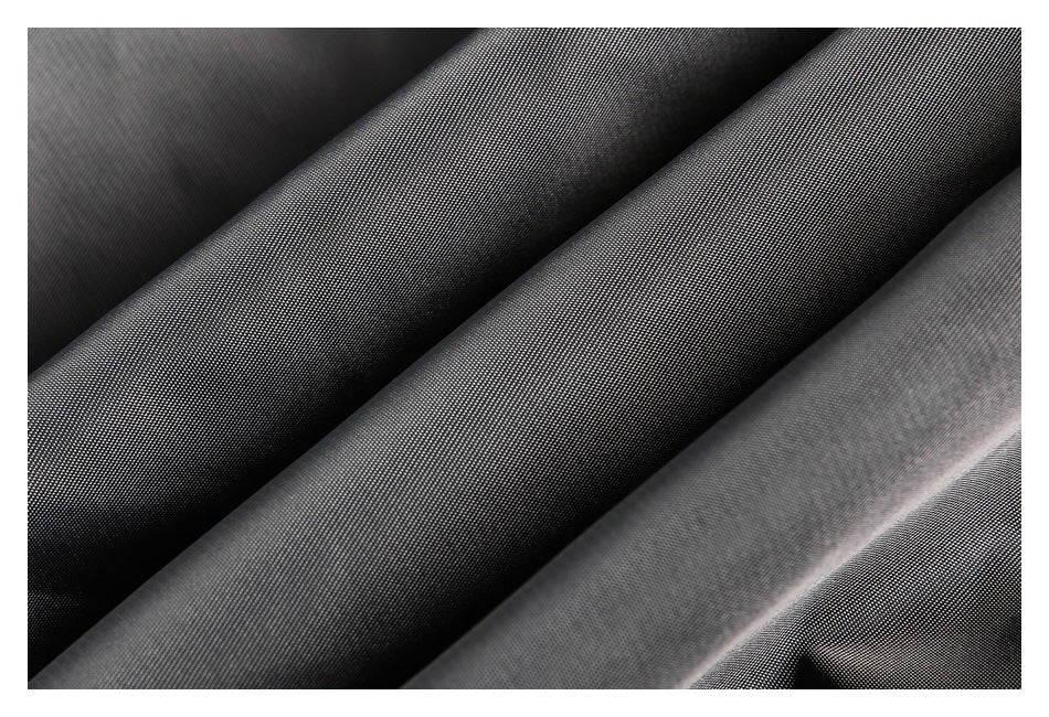 Close-up of dark gray fabric showing its fine woven surface and folds.