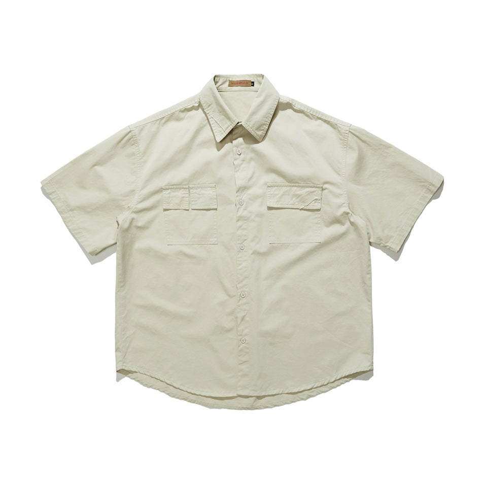 Beige short-sleeve button-up shirt with two flap chest pockets, flat lay front view