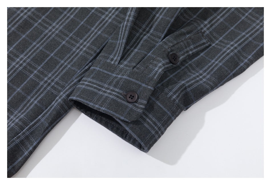 Close-up of a dark charcoal plaid sleeve cuff with two dark buttons.