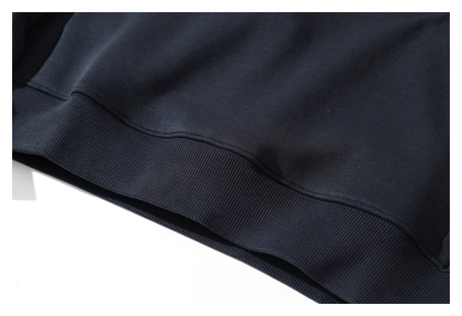Close-up of the dark navy pullover's wide ribbed hem and smooth body fabric.