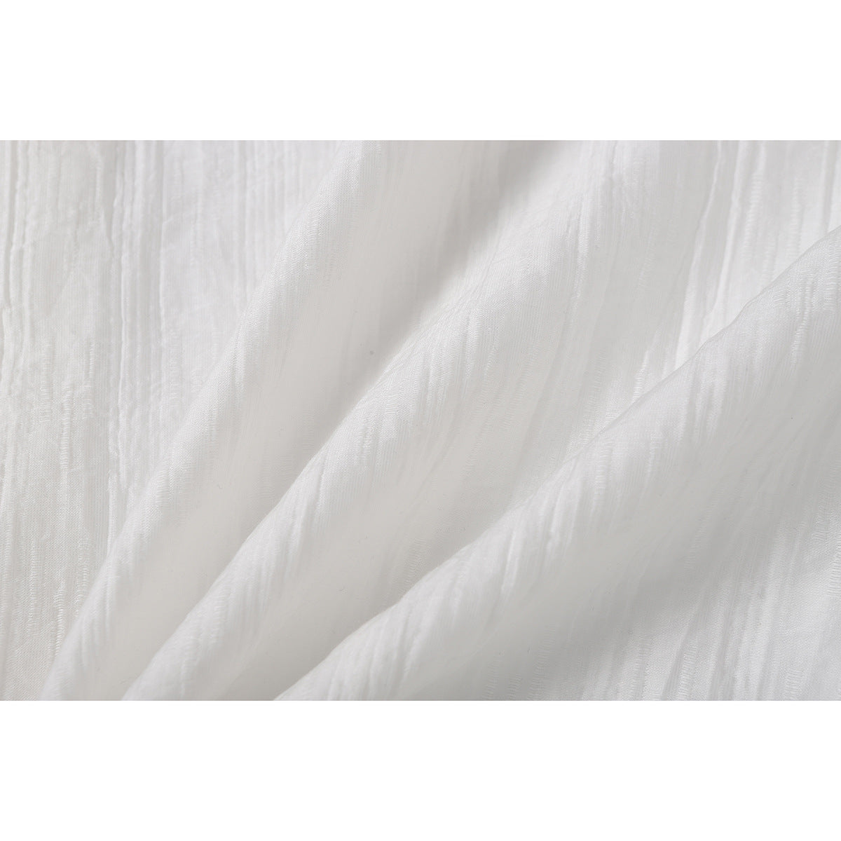 Close-up of the white shirt fabric, showing its subtle woven texture and folds.