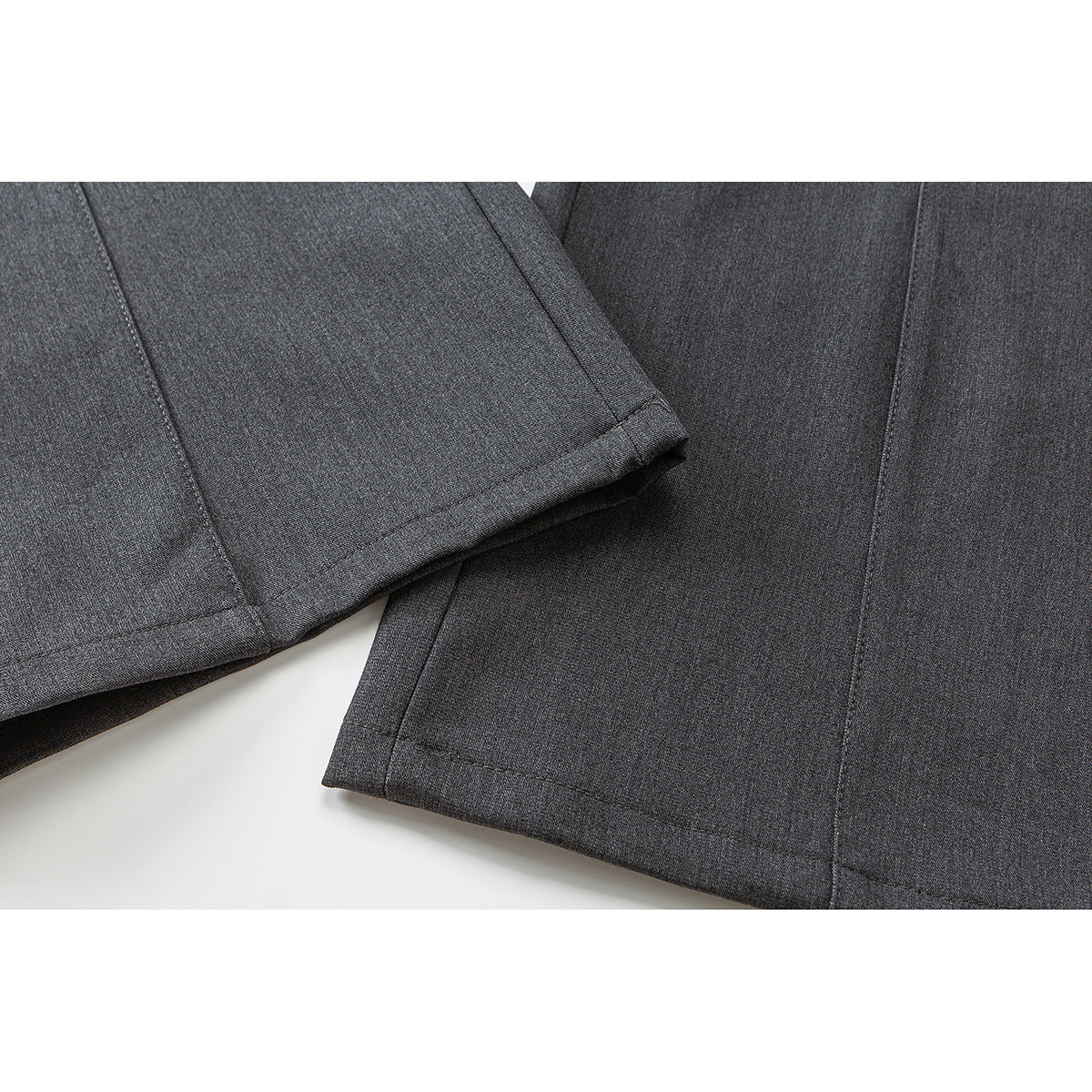 Close-up of dark gray trouser legs showing the stitched hems and straight seams.