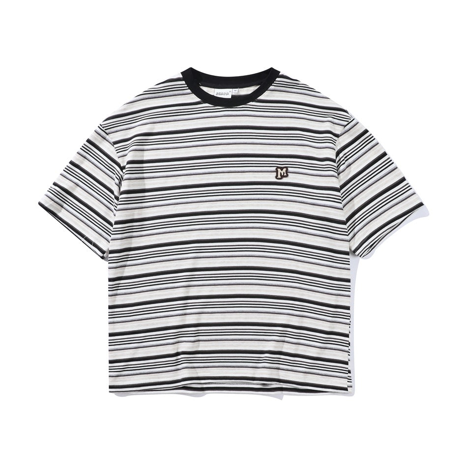 Black, white and beige striped short-sleeve crew-neck T-shirt with black collar and small M patch, flat front view