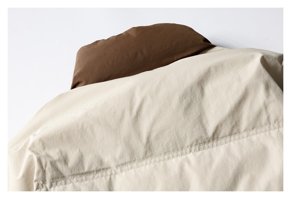 Close-up of a cream garment back with a brown collar and a horizontal stitched seam.
