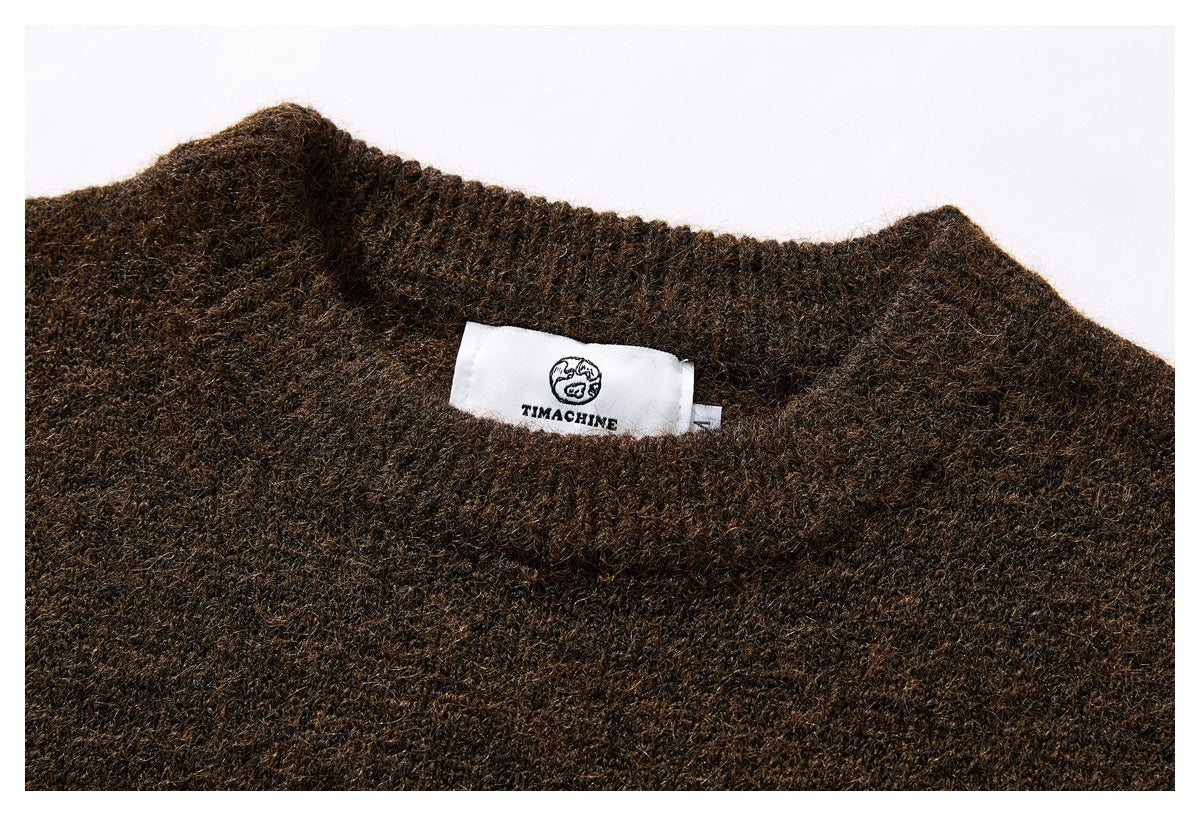 Close-up of a dark brown knit sweater's neckline and sewn-in brand label.