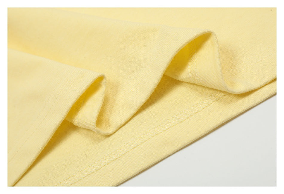 Close-up of pale yellow fabric folded to show its stitched hem.
