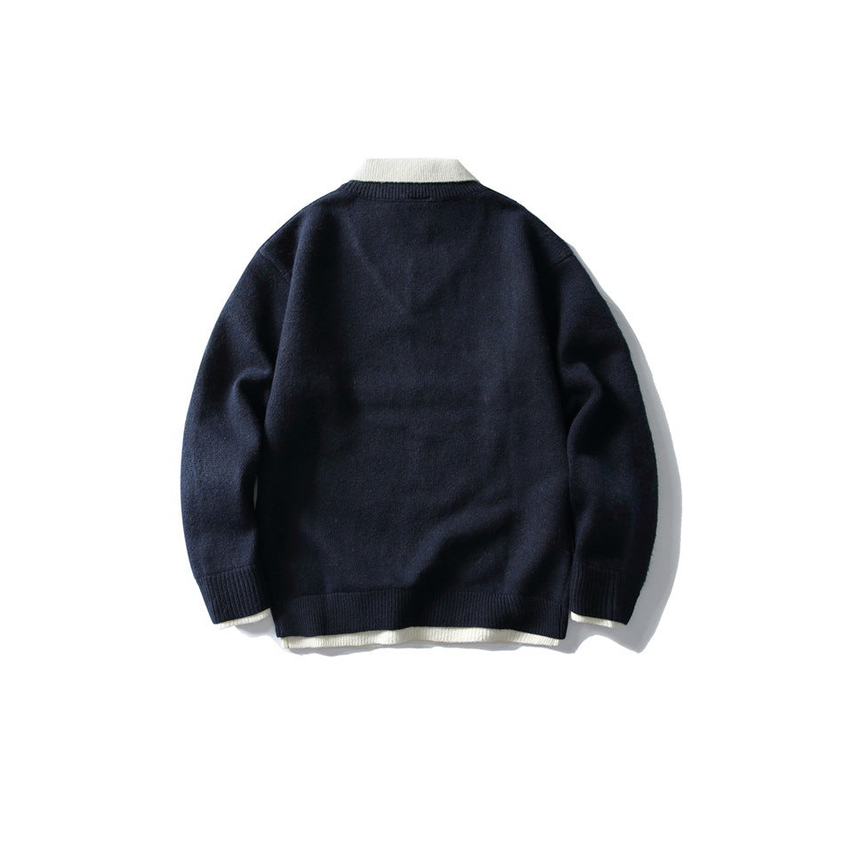 Back view of navy knit sweater with cream collar and layered cream hem, flat lay