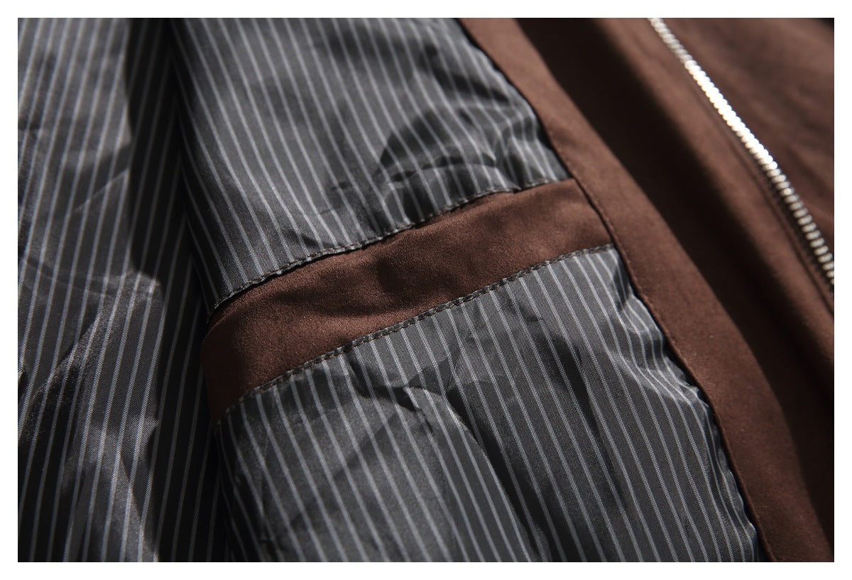 Close-up of a jacket's gray pinstriped lining, brown trim, and silver zipper.