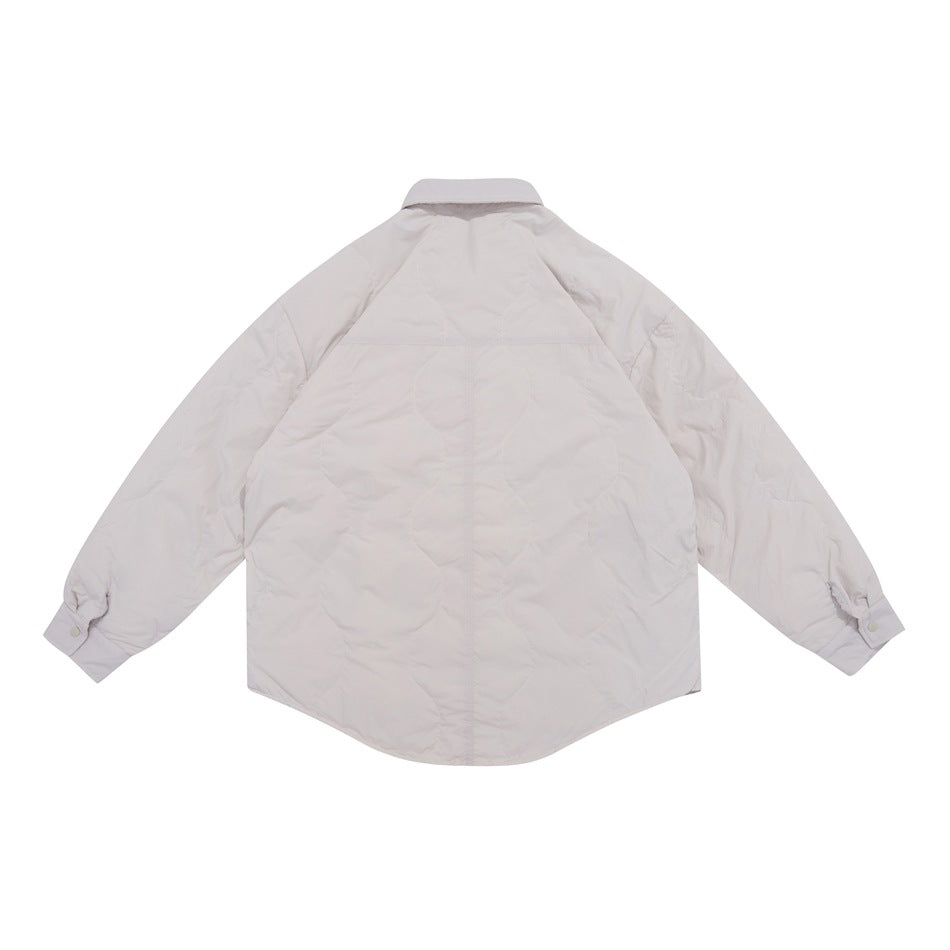 Back view of a pale blush-cream quilted shirt jacket with long sleeves and a rounded hem.