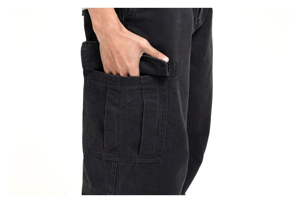 Close-up of black cargo pants showing a large side pocket with a flap and stitched panels.