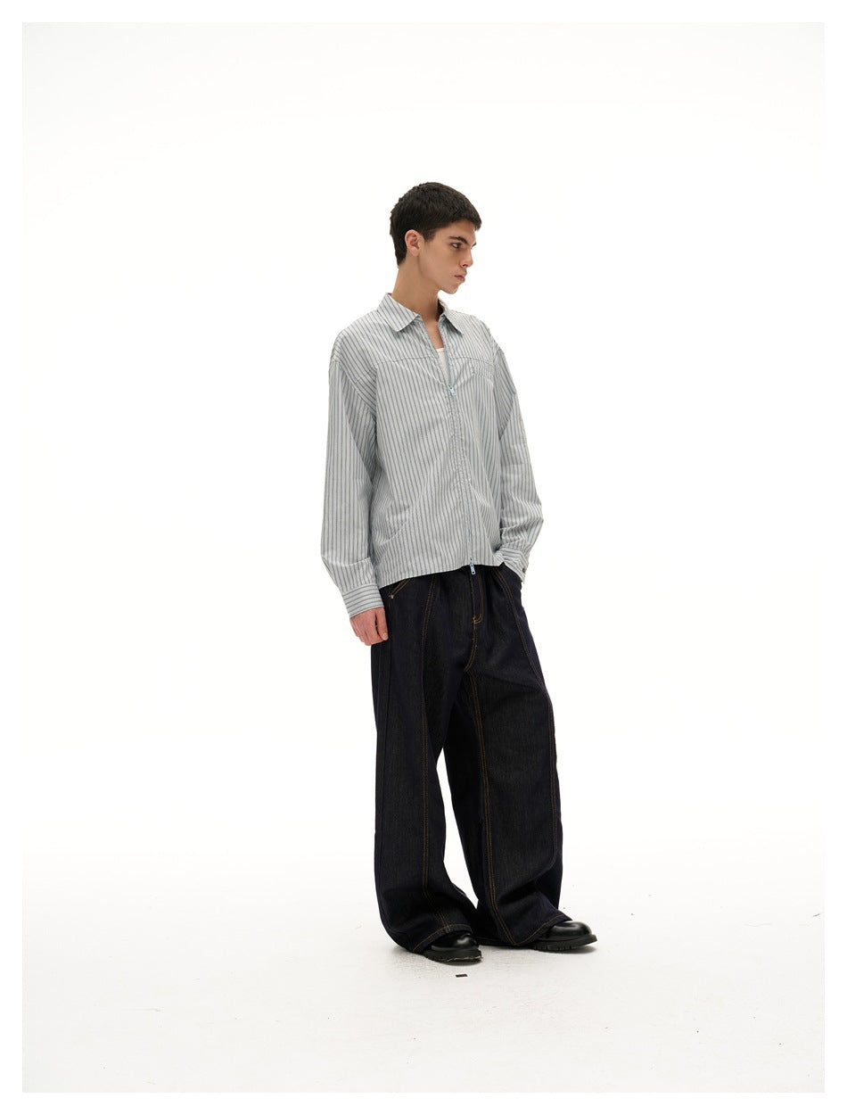 Three-quarter side view of a model wearing a gray vertical-striped collared shirt with a front zipper.