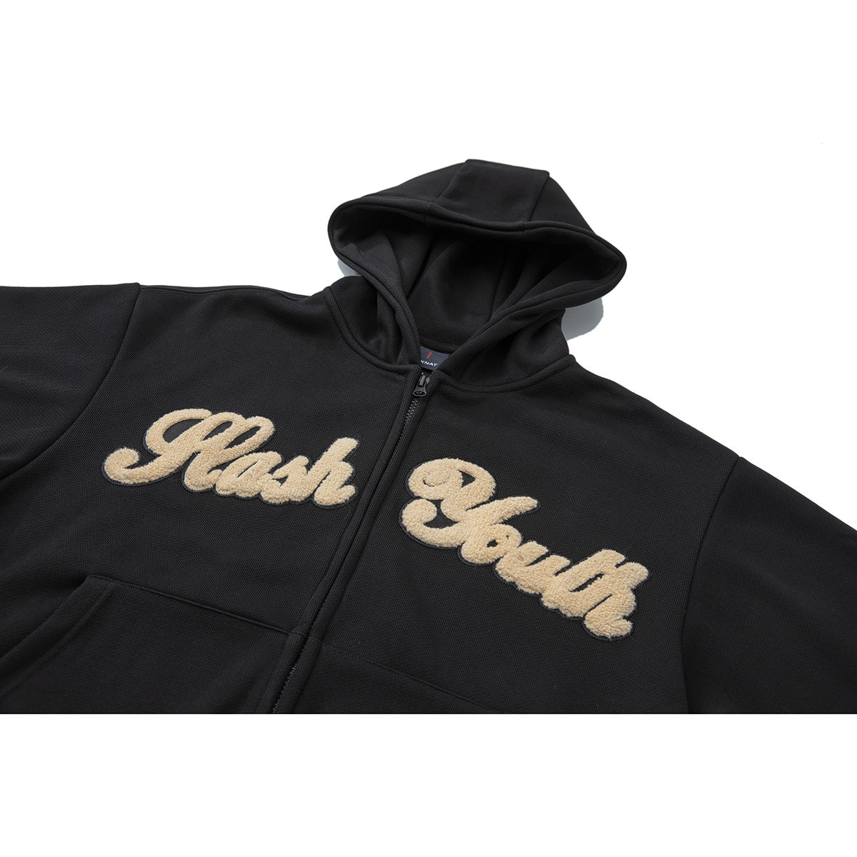 Close view of a black zip-up hoodie with a hood and cream embroidered “Flash Back” lettering on the front.