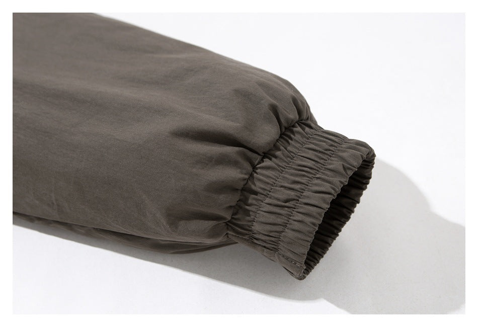 Close-up of a dark gray-brown sleeve ending in a gathered elastic cuff.