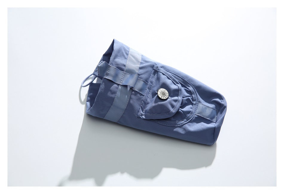 Folded blue cargo trousers with a flap pocket, metal snap, and webbing tabs on a white surface.