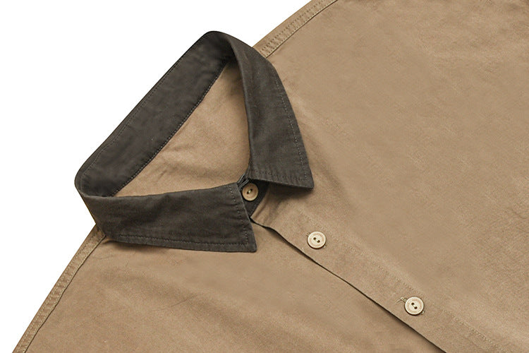 Close-up of a tan shirt with a dark contrasting collar and light front buttons.