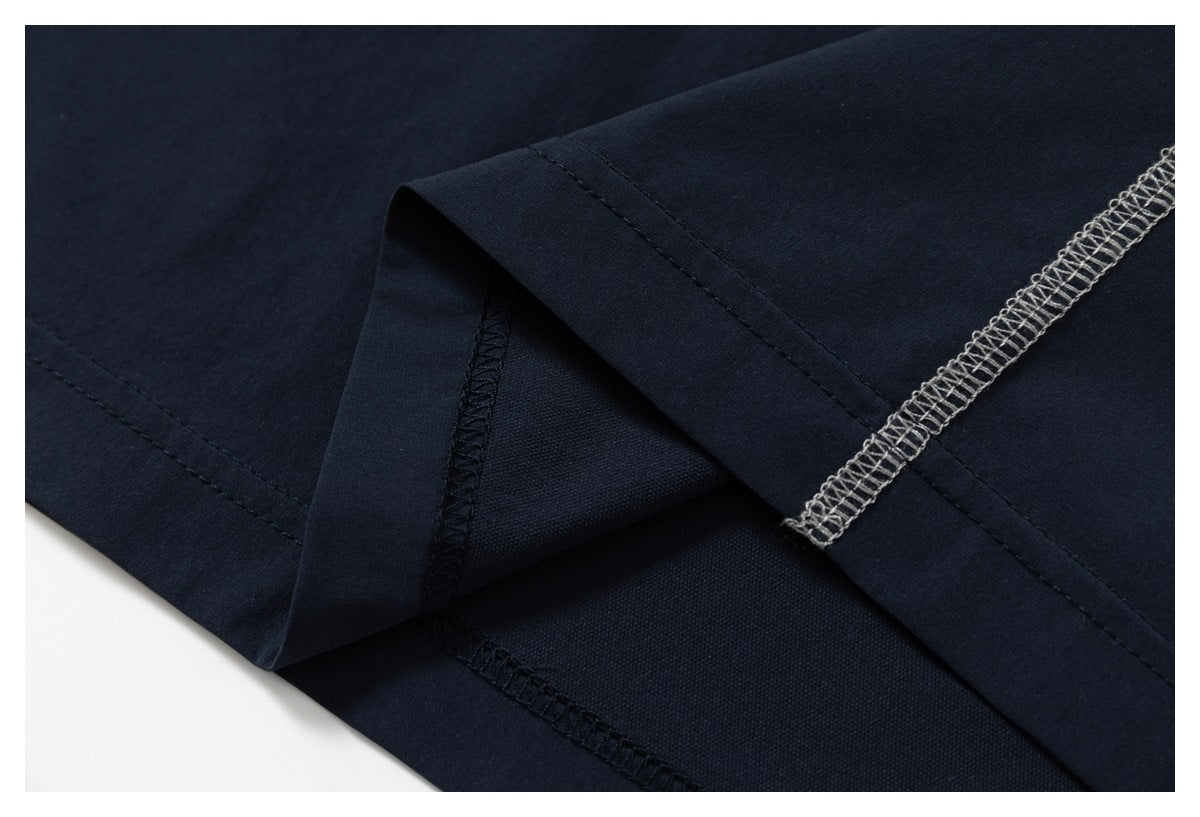 Close-up of dark navy garment construction, showing the folded hem and overlocked inner seams.