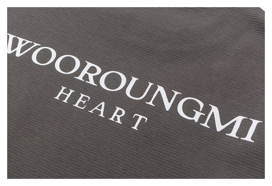 Close-up of white “WOOROUNGMI HEART” lettering printed on charcoal fabric.
