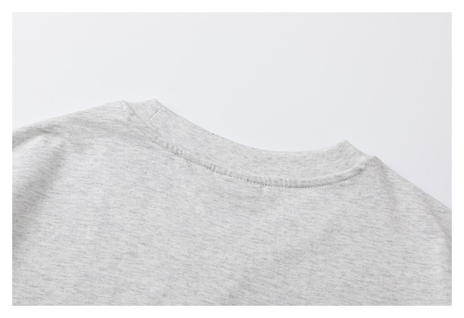 Close-up of the plain back neckline and shoulder area of a light gray heather T-shirt.