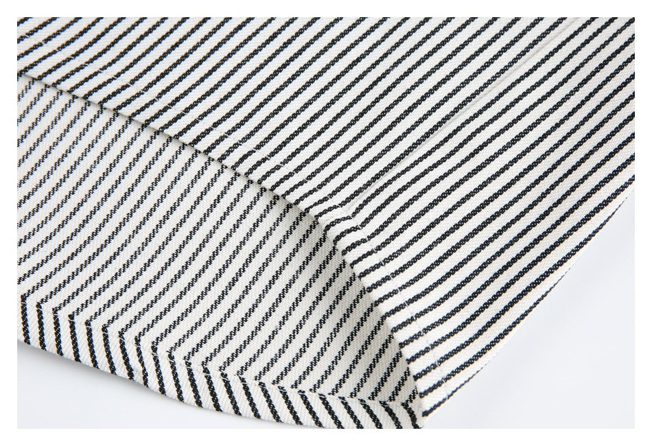 Close-up of a folded, stitched edge on black-and-white striped fabric.