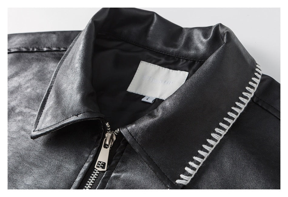 Close-up of the black jacket collar, zipper, white contrast stitching, and inner size label marked L.