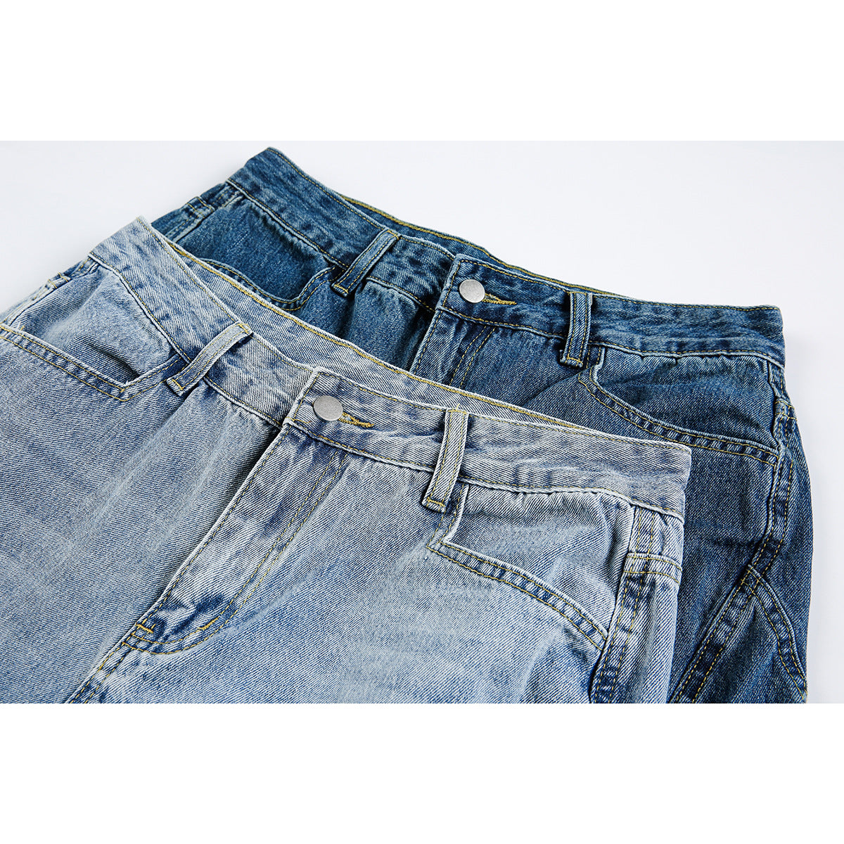 Close-up of light and dark blue denim shorts showing their waistbands, belt loops, buttons and front pockets.