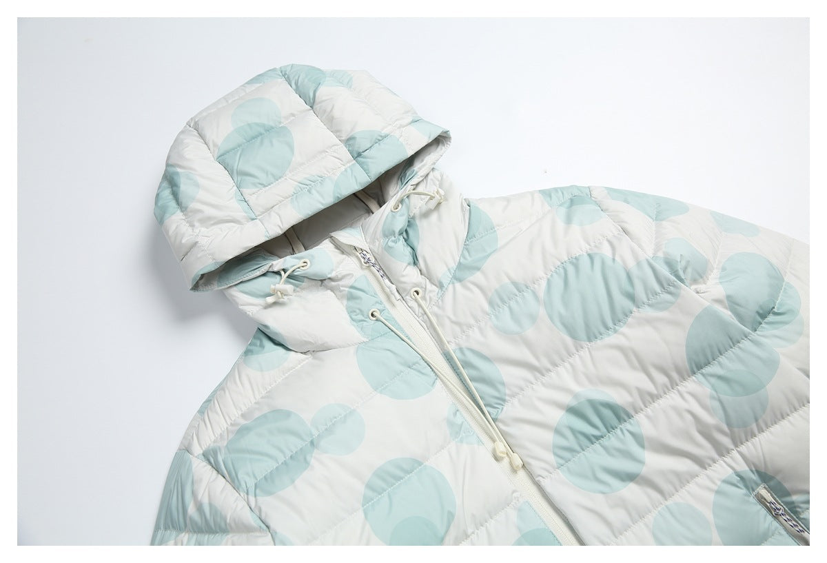 Angled close view of the jacket hood, drawcords, front zipper and pale aqua circle print.