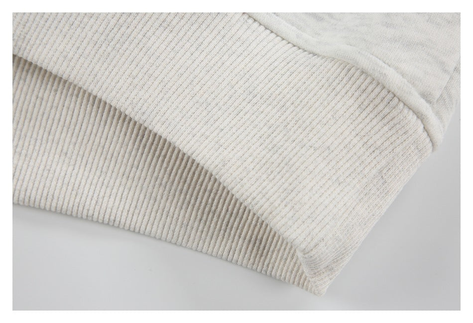 Close-up of a light heather-gray garment's wide ribbed hem or cuff.