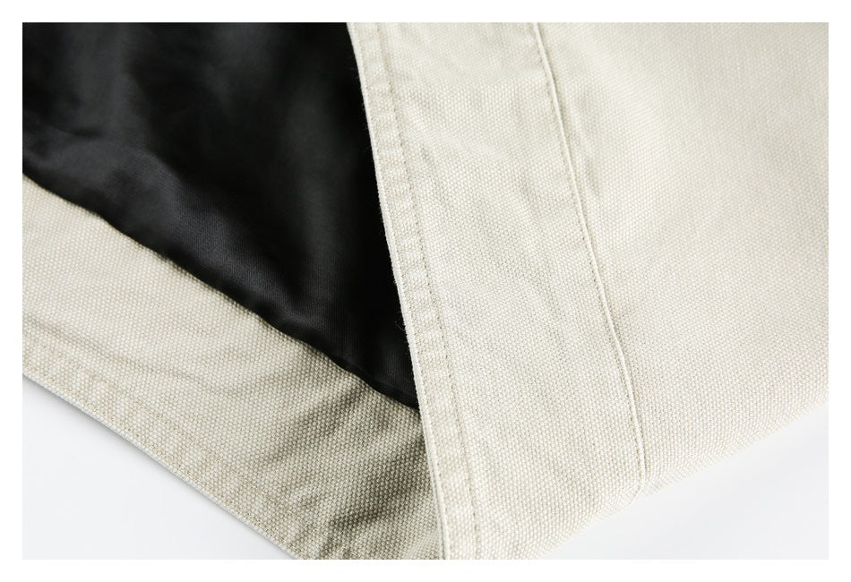 Close-up of a light beige garment opening with black lining visible inside.