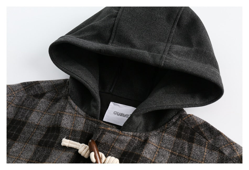 Close-up of the coat's charcoal hood, plaid shoulder fabric, and inner neck label.