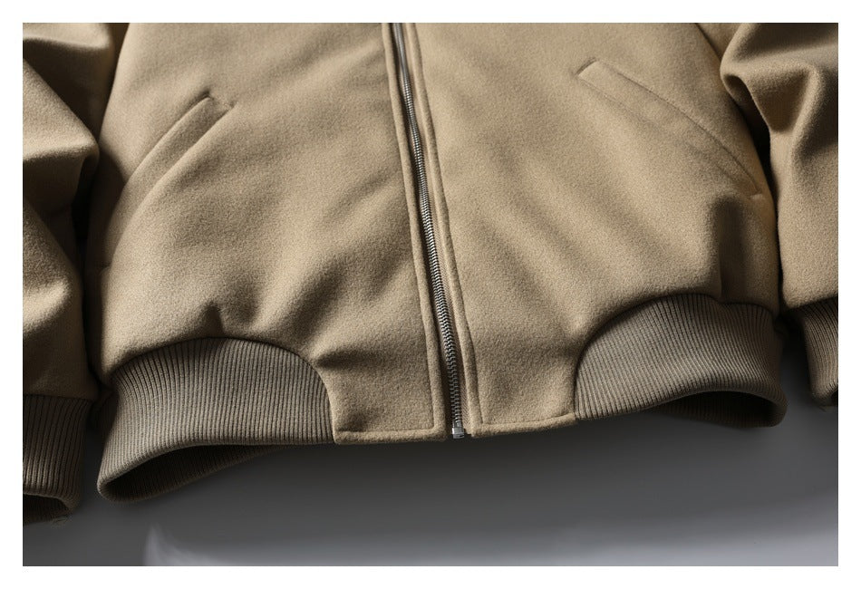 Close-up of a taupe zip-front jacket showing angled pockets and ribbed hem.