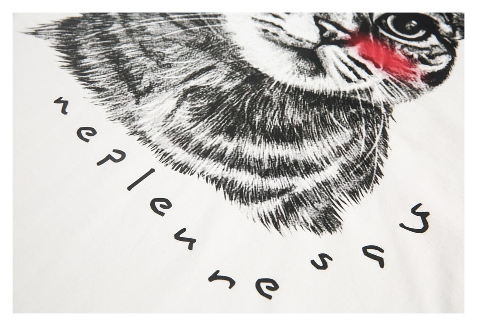 Close-up of the black-and-white cat print, red accents, and stylized lettering on white fabric.