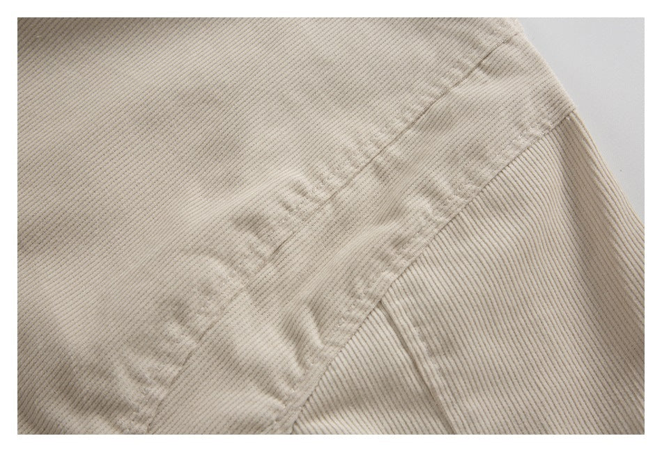Close-up of a diagonal stitched seam on cream ribbed fabric.