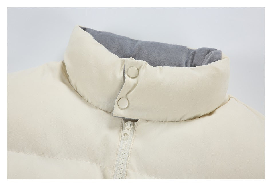 Close-up of the cream jacket's high collar, gray inner lining, two snap buttons, and front zipper.