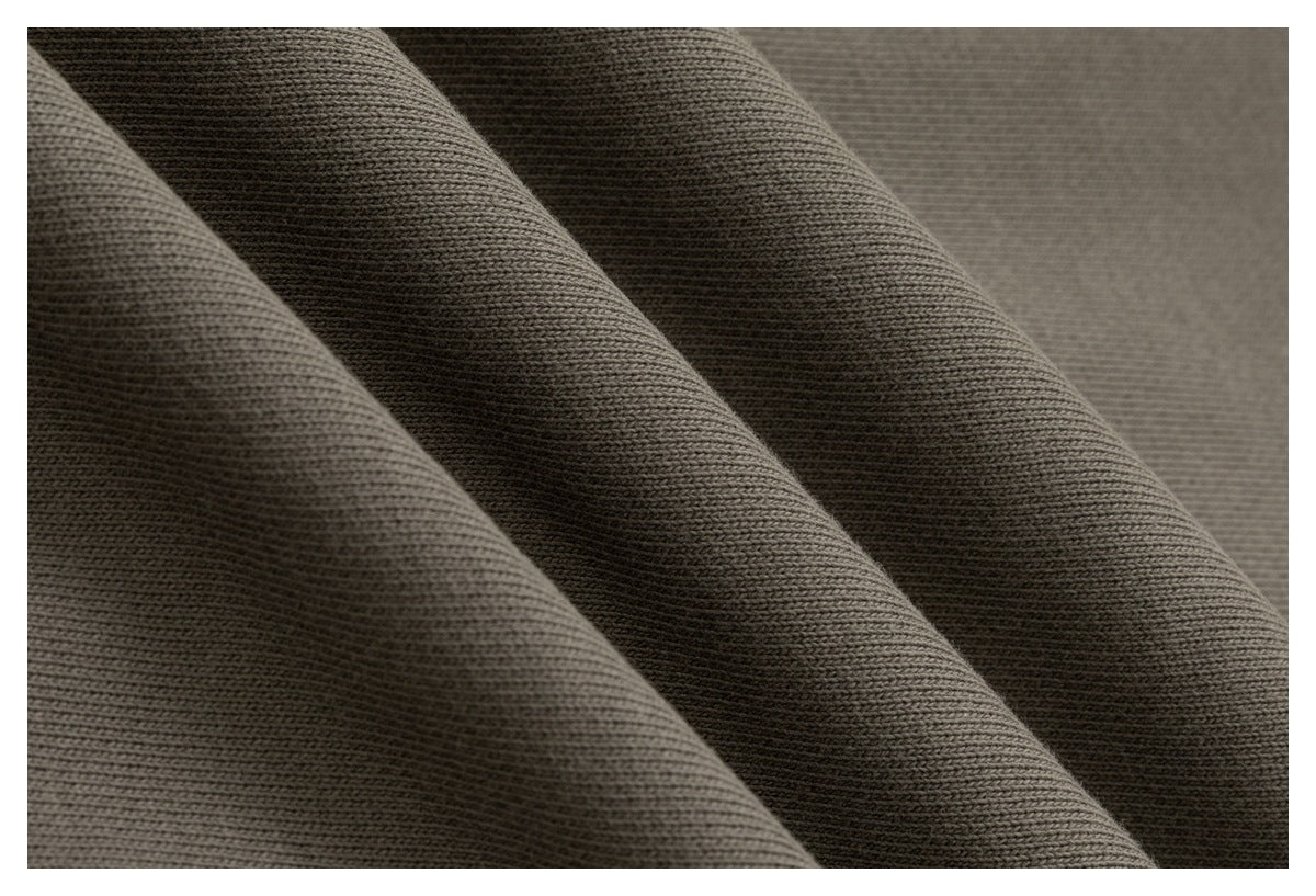 Close-up of muted olive-brown fabric showing its fine knit texture and soft folds.