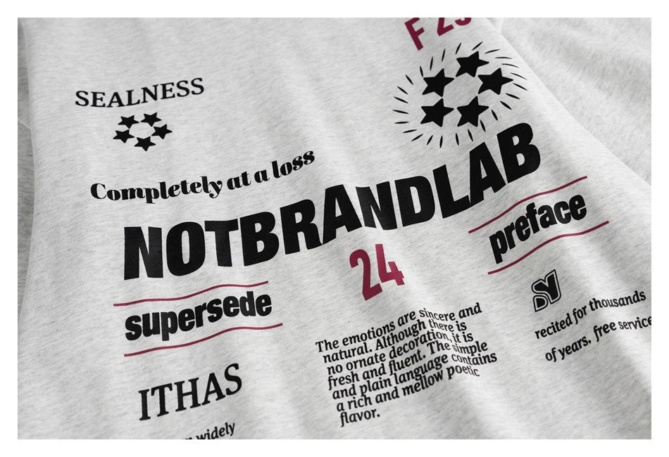 Close-up of a light gray heather garment with a large black and burgundy English text-and-star print.