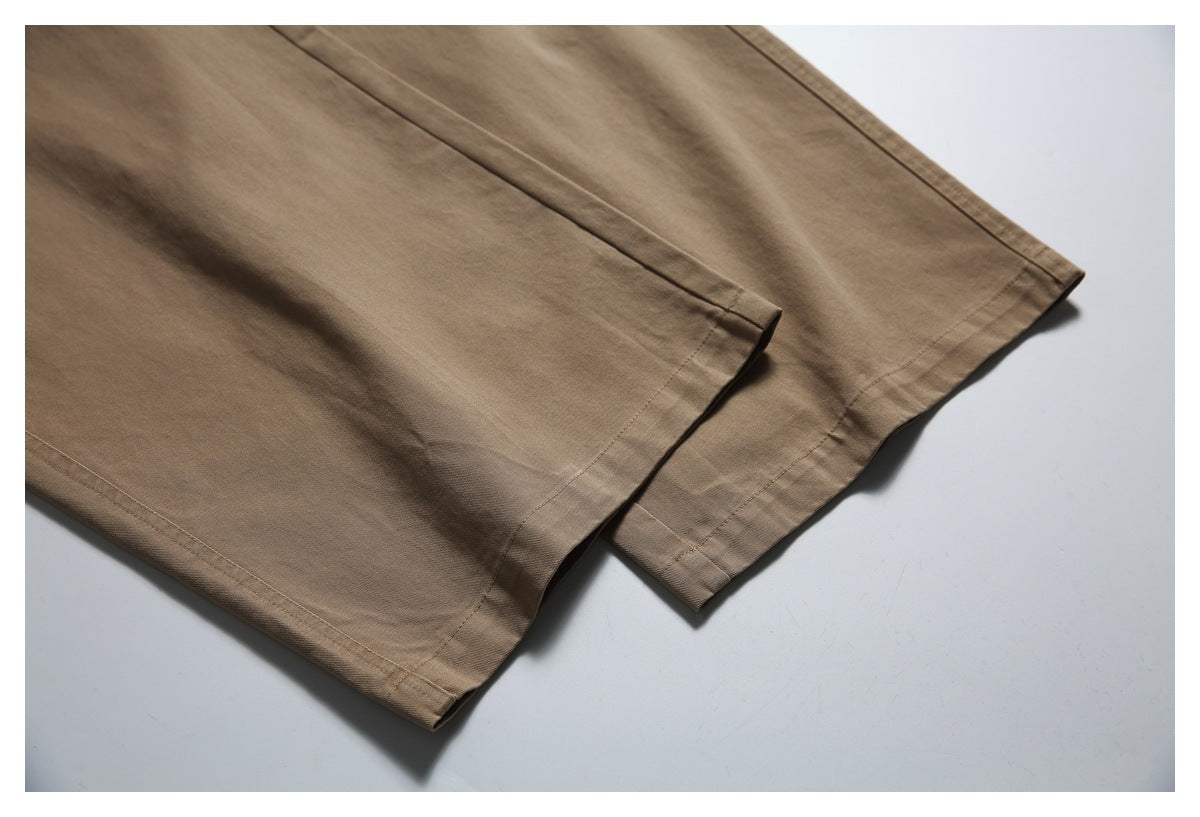 Close-up of the stitched hems on tan trouser legs.