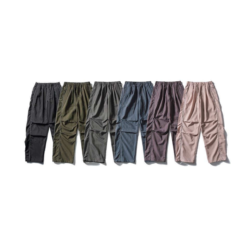 Six wide-leg drawstring pants in black, olive, gray, blue, purple and pink laid side by side