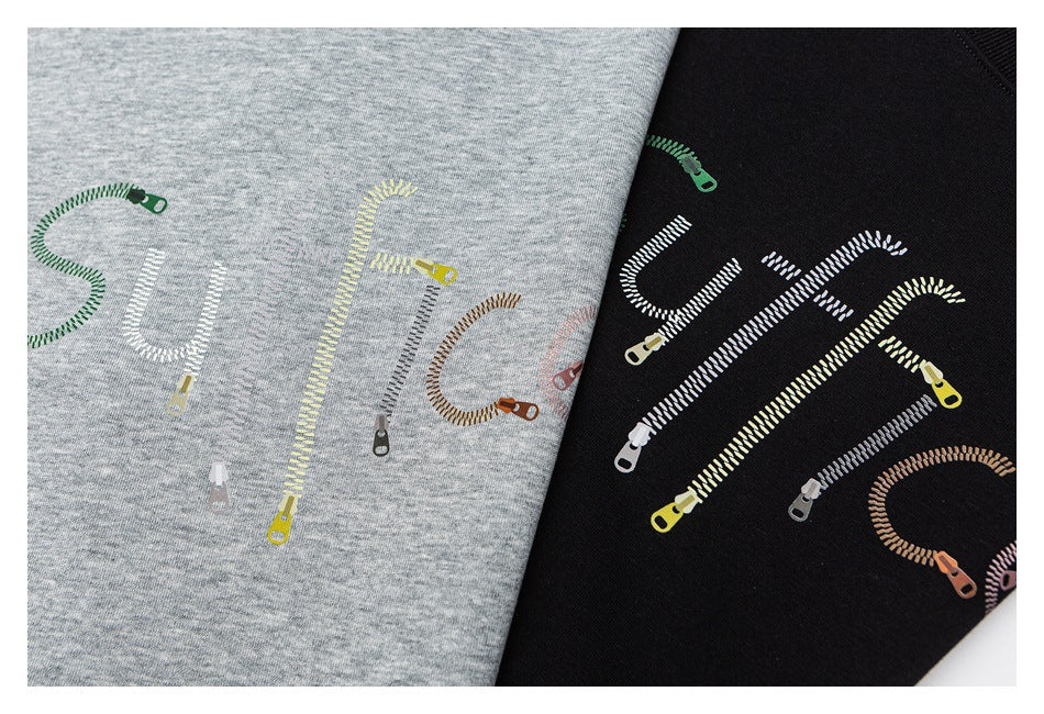 Close-up of colorful zipper-shaped lettering printed on heather gray and black sweatshirt fabric.