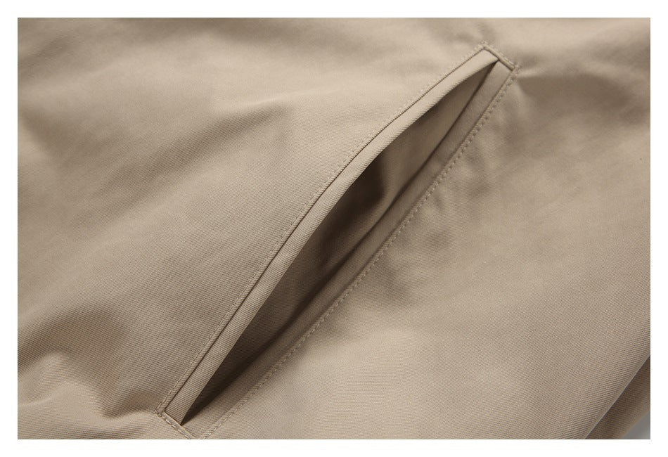 Close-up of a slanted welt pocket opening on a beige jacket.