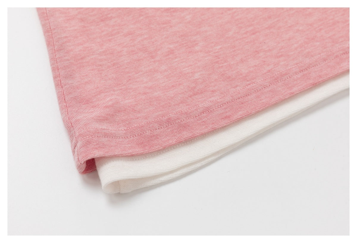Close-up of the heather-pink top’s hem layered over a white inner layer.