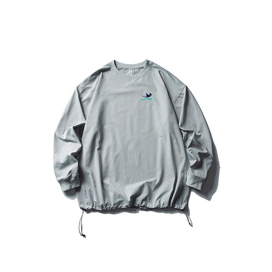 Gray long-sleeve crew-neck top flat lay with drawstring hem and small chest print