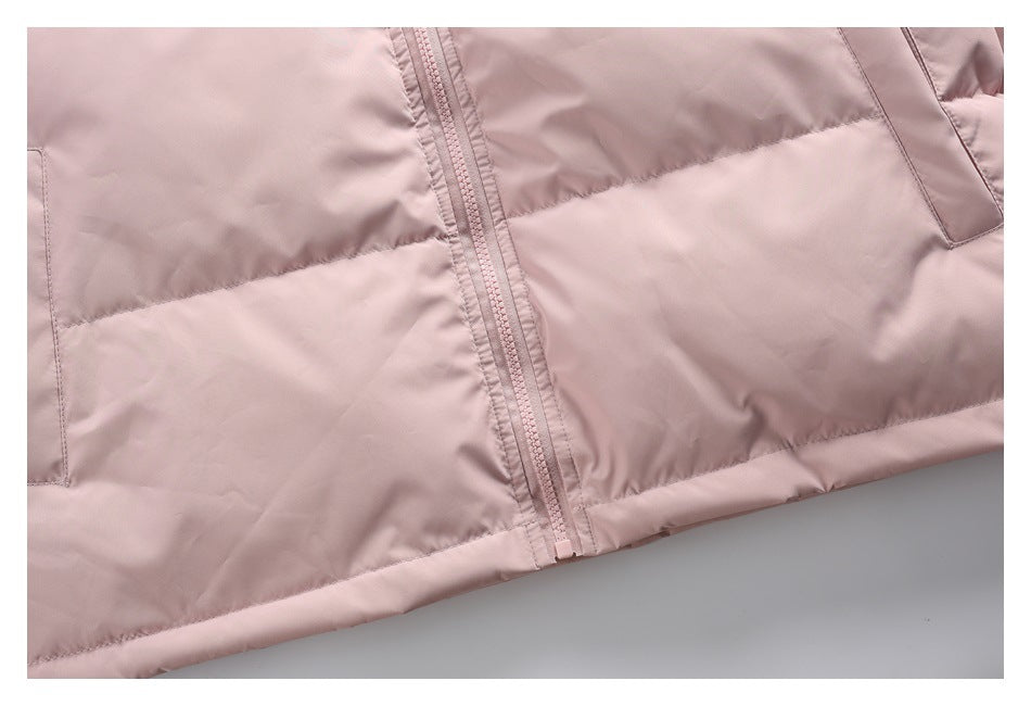 Close-up of the pale pink jacket's front zipper, quilted panels, and lower pocket openings.