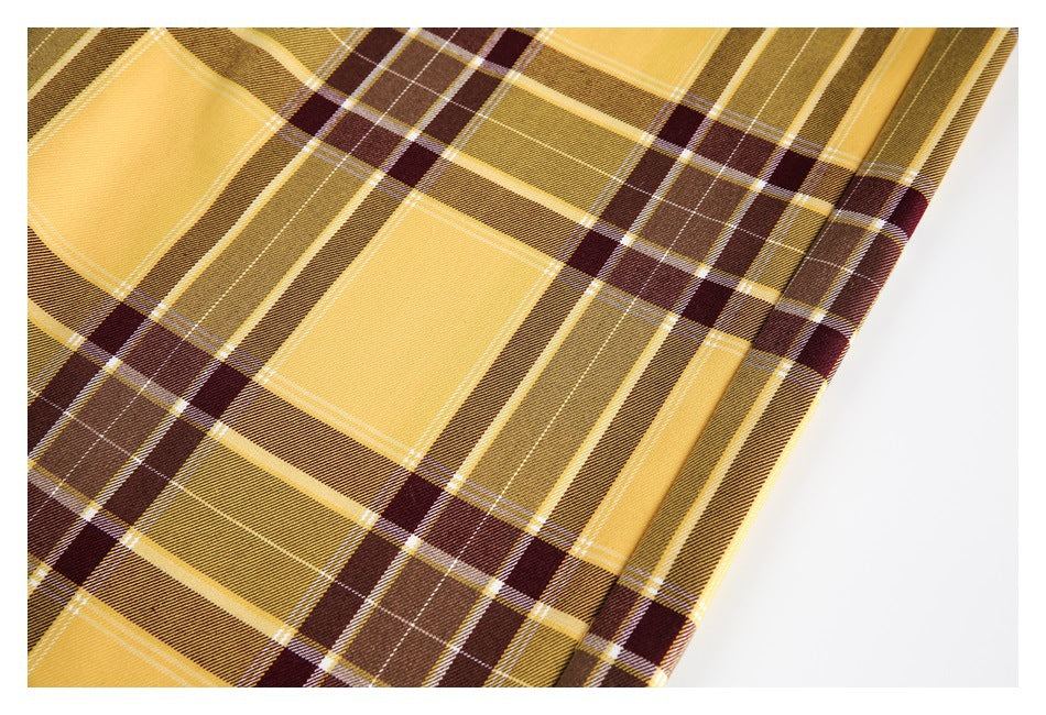 Close-up of mustard, brown and burgundy plaid fabric with a stitched seam.
