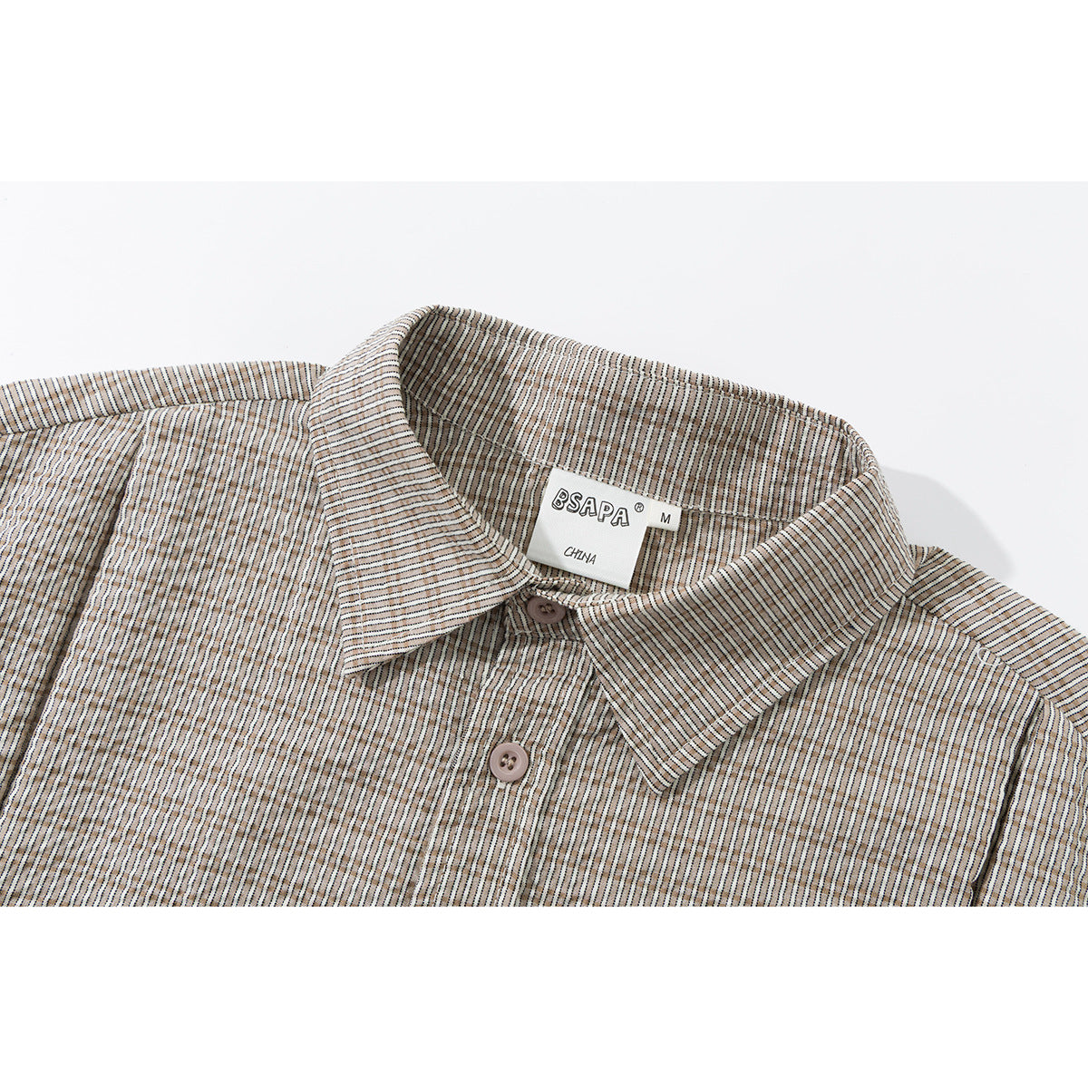 Close-up of a beige striped short-sleeve shirt collar, buttons, and neck label.