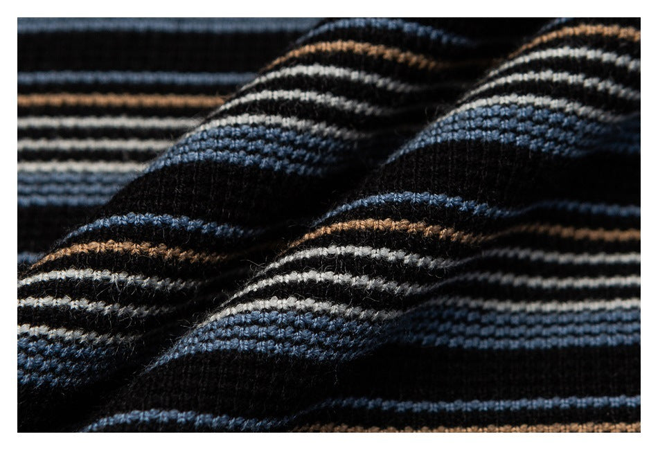 Close-up of black knit fabric with raised horizontal stripes in blue, cream, and tan.