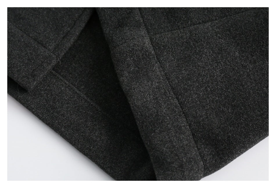 Close-up of the charcoal coat's overlapping front edges and wide lapel.