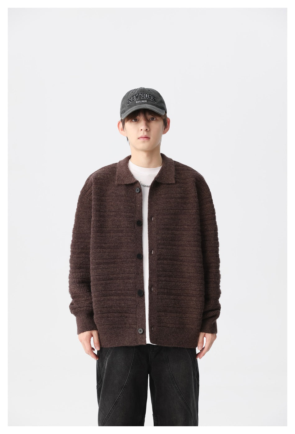 Front view of a model wearing a dark brown ribbed button-front cardigan with a collar.