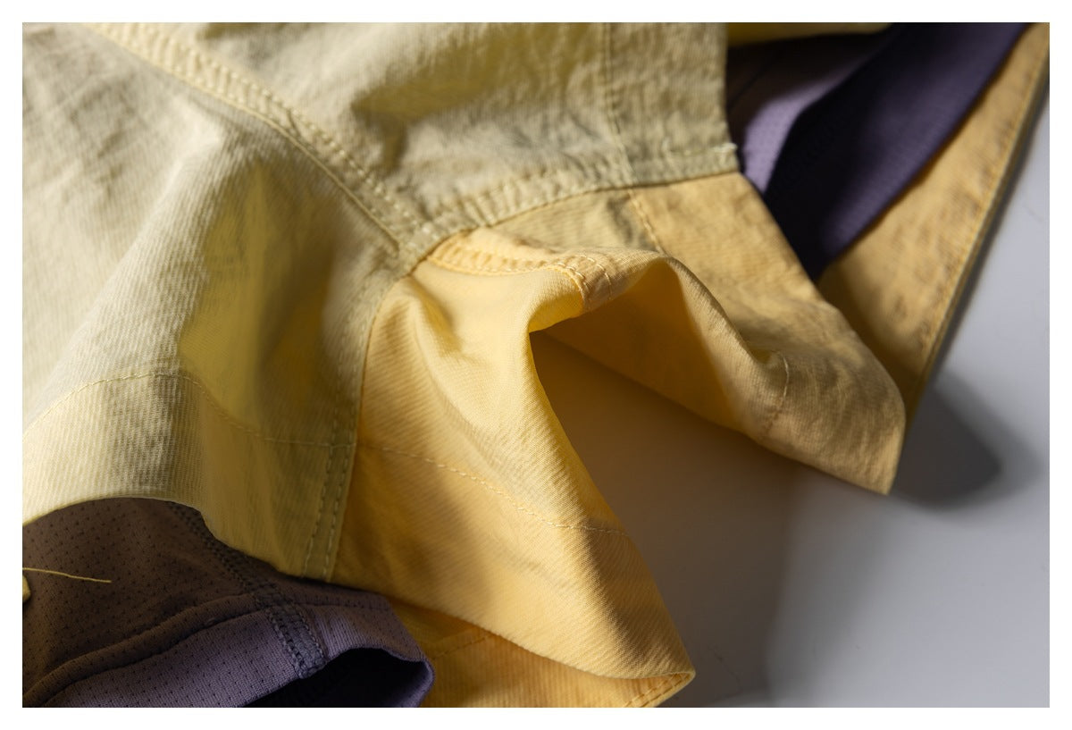 Close-up of the pale yellow shorts' inner seam and purple mesh lining.