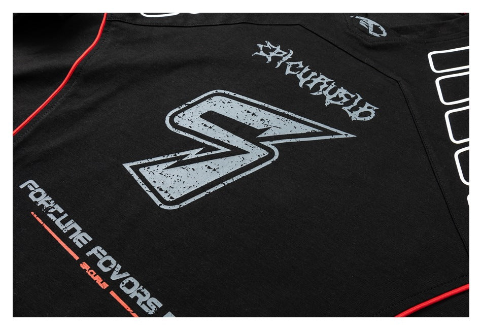 Close-up of a black shirt with distressed gray graphics, white lettering, and red piping.