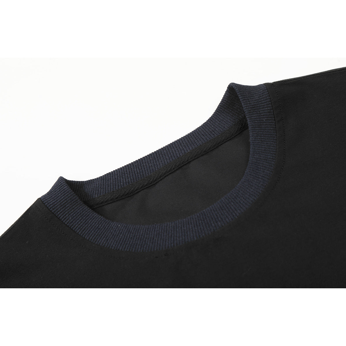 Close-up of a black T-shirt with a dark navy ribbed crew neckline.